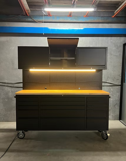 Workbench with storage drawers and a pegboard in a workshop setting